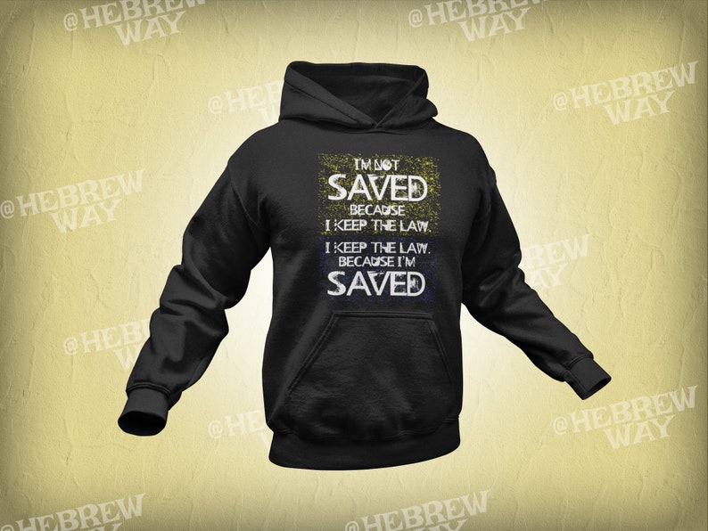 May include: Black hoodie with a white and yellow graphic print that says "I'm not saved because I keep the law. I keep the law because I'm saved."