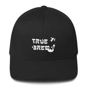 Puede incluir: Gorra de béisbol negra con un logotipo bordado en blanco que dice "TRUE BREW" con una flecha estilizada y un gráfico de una jarra de cerveza.