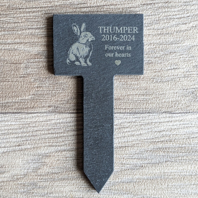 Puede incluir: Marcador de jard&iacute;n de pizarra negra con una silueta de conejo blanco y el texto "THUMPER 2016-2024 Forever in our hearts".