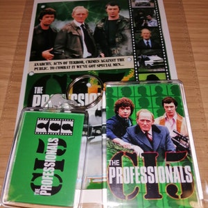 以下が含まれることがあります： 「The Professionals」の記念品コレクション。ポスターと2つのキーホルダーが含まれています。ポスターにはスーツとジャケットを着た男性グループが描かれています。キーホルダーは、番組のロゴと「The Professionals」の文字が入った緑色の背景です。