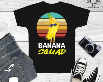 May include: Black t-shirt with a retro-style illustration of a banana wearing sunglasses and the text "Banana Squad".