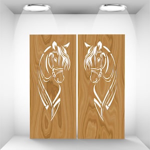 Puede incluir: Dos paneles de madera con un patrón de veta clara. Cada panel presenta un diseño de cabeza de caballo blanco estilizado. Las cabezas de los caballos se enfrentan, con crines y bridas detalladas. Los paneles se exhiben en un espacio blanco iluminado.