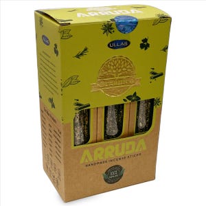 May include: A box of "ARRUDA" handmade incense sticks. The box is primarily yellow and brown, with the brand name and product description in green and white. The box features a gold foil seal that reads "Organico". The incense sticks are visible through a cutout.