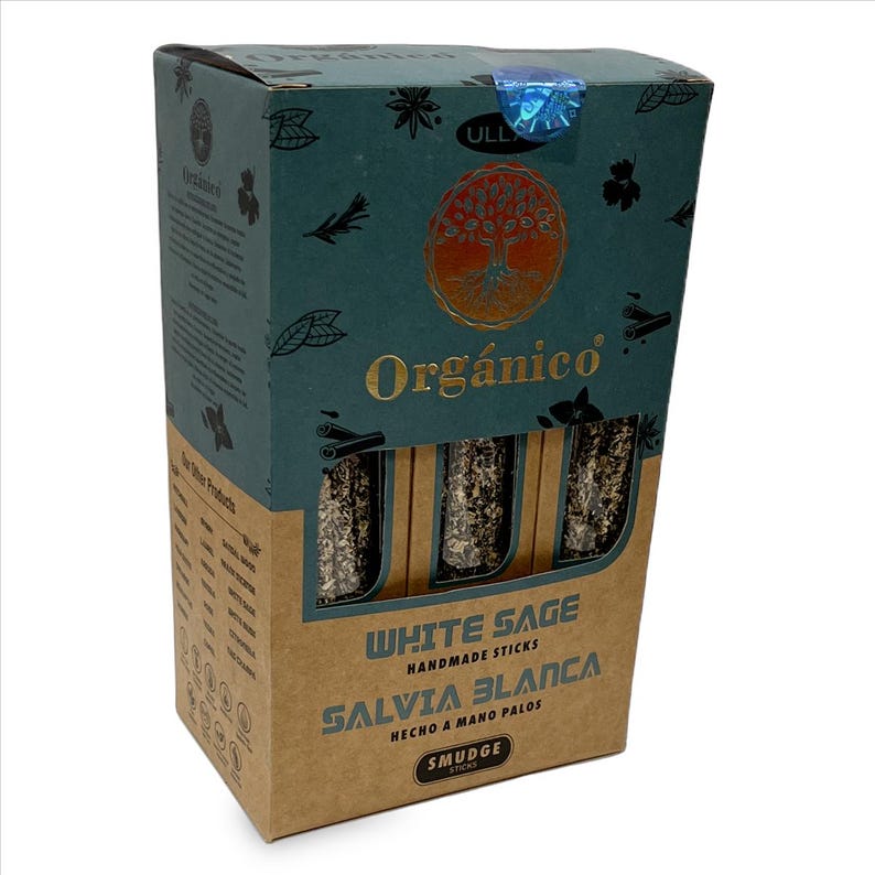 May include: A box of "Org&aacute;nico" white sage smudge sticks. The box is teal and brown with gold lettering and a tree of life design. The text "WHITE SAGE" and "SALVIA BLANCA" are visible on the front of the box.