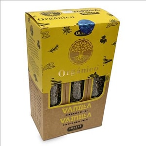 May include: A yellow and brown box labeled "Org&aacute;nico" with a tree logo, containing vanilla handmade sticks. The box has a blue seal and decorative leaf and spice illustrations. The text "Vanilla Handmade Sticks" is visible.