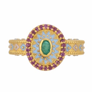 Peut inclure: Bague en or ornée d'une pierre centrale ovale émeraude, entourée d'un motif en étoile bleu clair et or. La bague est ornée de petites pierres roses rondes. Le bracelet présente un motif géométrique répétitif.
