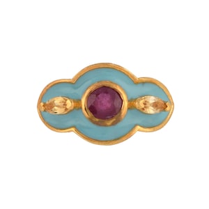 Peut inclure: Broche dorée avec un fond en émail bleu clair. La broche présente un rubis ovale central et deux accents dorés en forme de feuille. Le design est symétrique et élégant, adapté aux tenues de soirée.