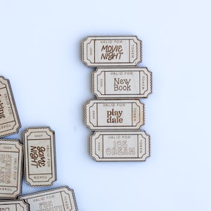 May include: A set of wooden tokens with different activities printed on them, such as "Movie Night", "New Book", "Play Date", "Ice Cream", "Game Night", "Fun Activity", "Wild Card", "Trip Park", "Staying Up Late", and "Lunch Picnic".