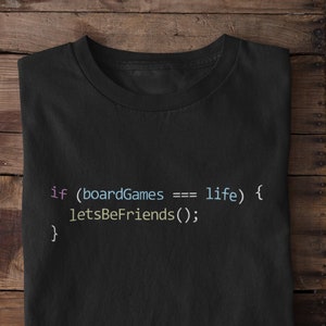 May include: A black t-shirt with a code snippet printed on it. The code reads "if (boardGames === life) { letsBeFriends(); }"