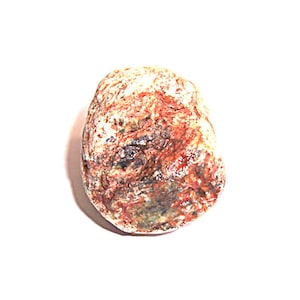 May include: A small, rounded stone with a rough texture. The stone displays a mix of colors, including shades of red, brown, white, and hints of green and black. The stone is set against a plain white background.