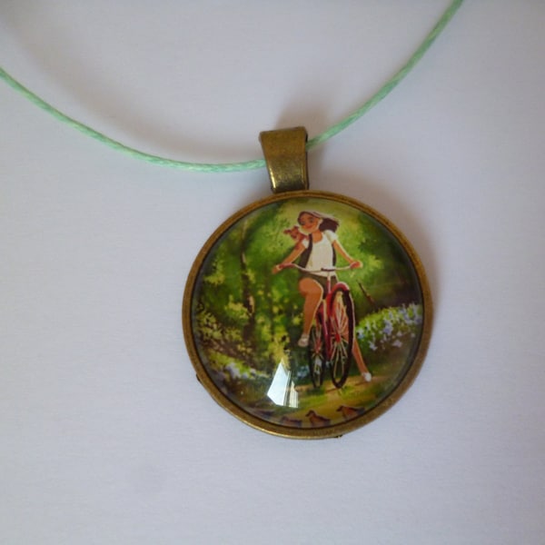 collier bronze cabochon jeune fille et son chien a vélo 25mm