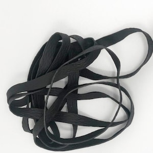 May include: Black elastic shoelace with a textured surface.
