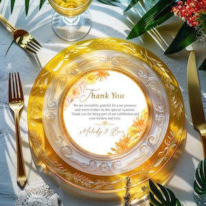 May include: A white card with a floral design and the text "Thank You" with the message "We are incredibly grateful for your presence and warm wishes on this special occasion. Thank you for being part of our celebration and your kindness and love. Melody & Ben". The card is on a gold and white patterned plate.