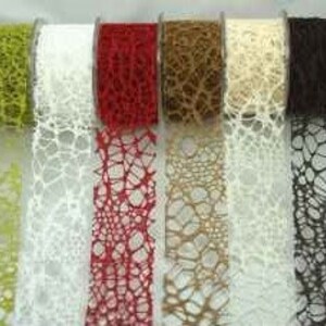 May include: Five spools of decorative ribbon with a lace-like pattern. The ribbon colours are green, white, red, brown, and black.