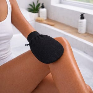 Venice Gold exfoliating mitt in use on leg, gently buffing skin to remove dead skin cells and prep for an even self tan