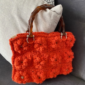 Handgemachte orange gehäkelte Handtasche.