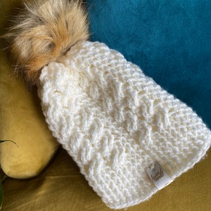 Cream winter woollen hat with detachable faux fur pom pom .