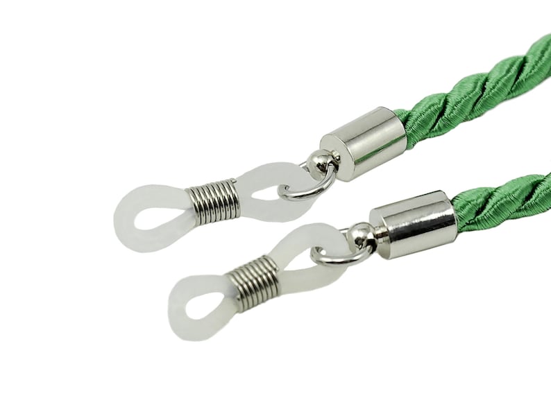 May include: Green braided cord eyeglasses retainer with silver metal ends and clear plastic loops.