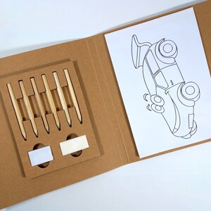 Peut inclure: Un kit de bricolage avec un dossier en carton brun, contenant six crayons et une page &agrave; colorier avec un contour de voiture. Les crayons sont dispos&eacute;s dans un support rectangulaire.