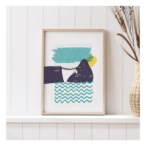May include: A framed abstract print with a teal, blue, and yellow colour scheme. The print features a stylised mountain with a small house on top, a wavy line representing water, and a dotted sky.