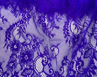 May include: Purple lace fabric with a floral pattern. The lace has a scalloped edge.