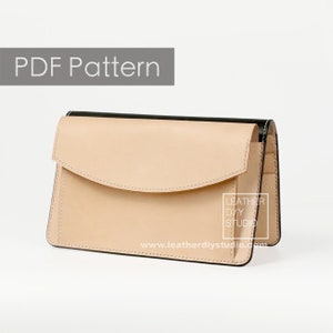 Könnte beinhalten: Eine beige Ledergeldbörse mit Klappenverschluss und schwarzem Lederbesatz. Die Geldbörse hat ein kleines Fach auf der Vorderseite und der Text "LEATHER DIY STUDIO" ist seitlich aufgedruckt. Der Text "www.leatherdiystudio.com" ist unten aufgedruckt.