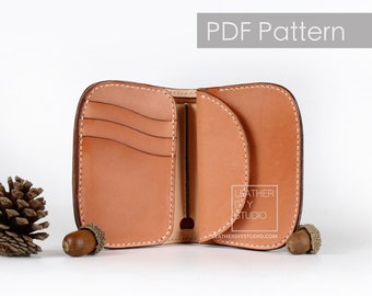 May include: Open, light brown leather wallet with multiple card slots and a curved design. The wallet is stitched with white thread and has the text "PDF Pattern". The wallet is open, revealing the interior. The logo "LEATHER DIY STUDIO" is visible.