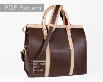 Peut inclure: Un sac de voyage en cuir marron avec des finitions en cuir beige et une bandoulière en cuir beige. Le sac a une poche avant et le texte "LEATHER D/Y STUDIO" est imprimé sur le côté.
