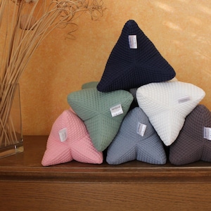 Könnte beinhalten: Ein Set aus sechs dreieckigen Kissen in verschiedenen Farben, darunter marineblau, weiß, grün, rosa, grau und braun. Die Kissen sind aus einem Waffelstoff gefertigt und haben eine strukturierte Oberfläche.