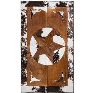 May include: A brown, white, and black cowhide rug with a large five-pointed star in the center. The star is made of different colored cowhide pieces. The rug has a black border.