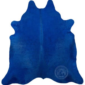 May include: A bright blue cowhide rug. The rug is made of real cowhide and has a natural, rustic look. It is perfect for adding a touch of style and warmth to any room.