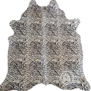 May include: A white cowhide rug with a black zebra print pattern.