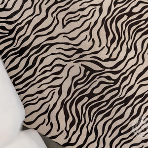May include: Black and white zebra print rug with a wavy pattern.