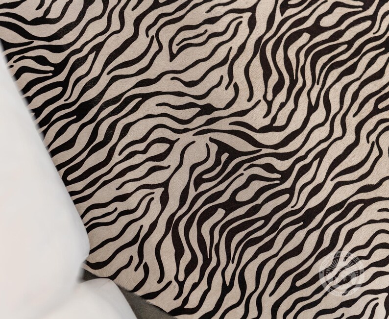 May include: Black and white zebra print rug with a wavy pattern.