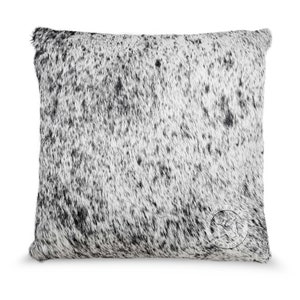 May include: A white and black cowhide pillow with a black leather tag that says "Cowhide" in white lettering.