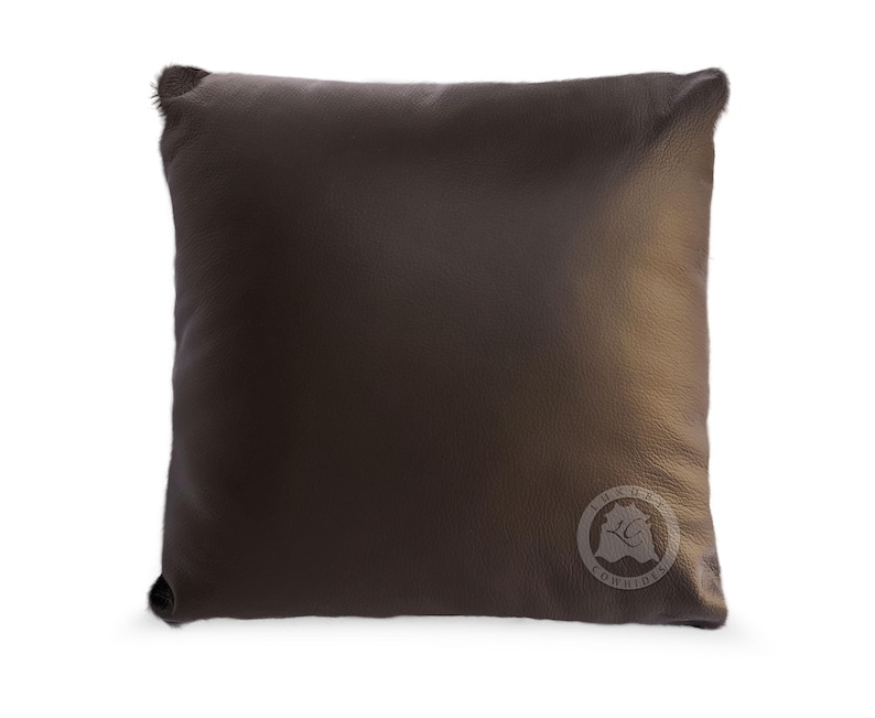 May include: A dark brown leather pillow with a circular logo that says "Luxury Comfort" in white text.