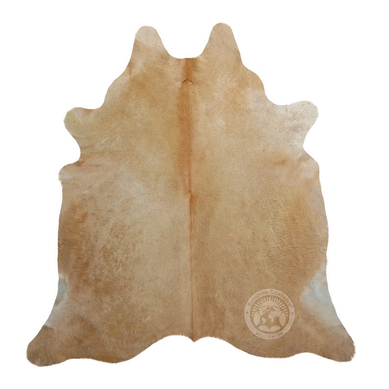 May include: A light brown cowhide rug with a natural, slightly distressed look. The rug is soft and fluffy, with a subtle sheen. It is a great addition to any home decor.