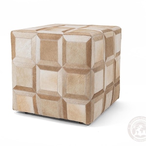K&ouml;nnte beinhalten: Ein quadratischer Hocker mit einem geometrischen Muster aus beigefarbenem und hellbraunem Rindsleder. Der Hocker besteht aus mehreren zusammengen&auml;hten Lederst&uuml;cken.
