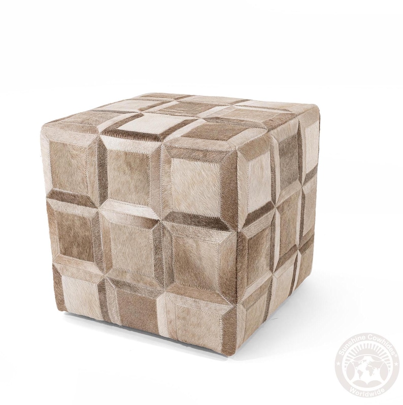 Pu&ograve; includere: Un pouf quadrato con un motivo geometrico realizzato in pelle di mucca di diverse tonalit&agrave; di marrone e beige.