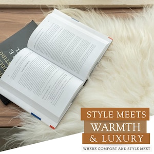 Puede incluir: Un libro abierto con texto, sobre una alfombra esponjosa de color crema. Otro libro cerrado es visible en el fondo. La imagen incluye el texto "STYLE MEETS WARMTH & LUXURY WHERE COMFORT AND STYLE MEET."