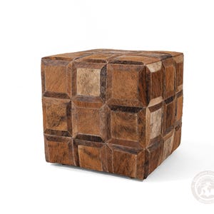 K&ouml;nnte beinhalten: Ein brauner Lederhocker mit geometrischem Muster. Der Hocker besteht aus Quadraten aus braunem Leder in verschiedenen Farbt&ouml;nen.