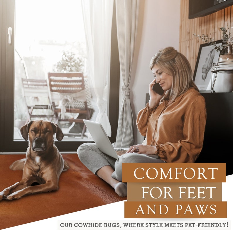 May include: A woman sits on a brown cowhide rug with a laptop and a dog. The rug is in a living room with a window and a chair. The text on the rug reads "COMFORT FOR FEET AND PAWS OUR COWHIDE RUGS, WHERE STYLE MEETS PET-FRIENDLY!"