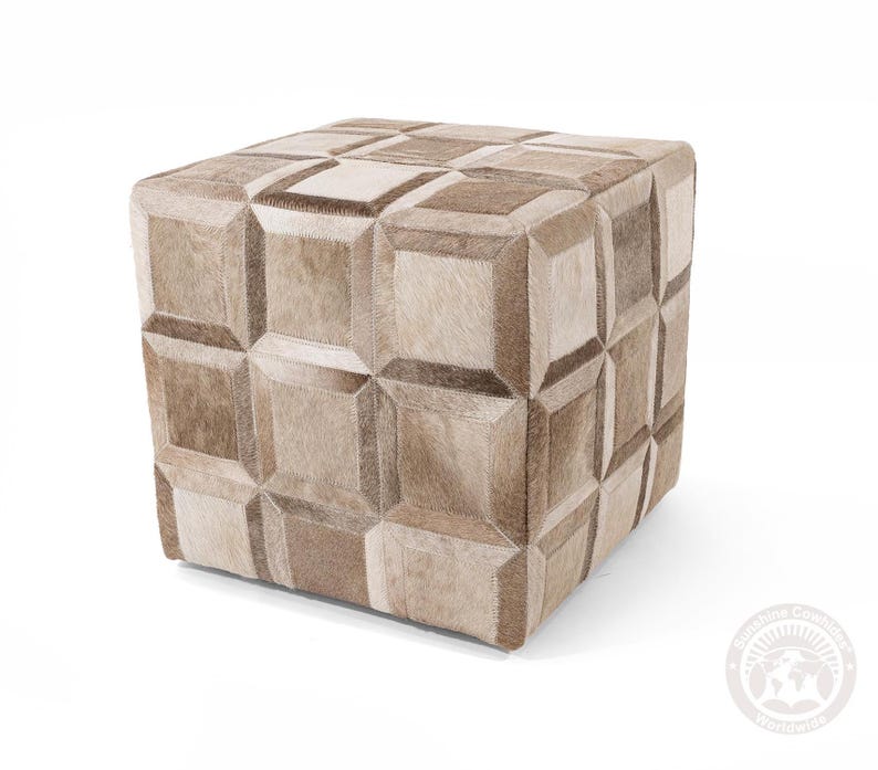 K&ouml;nnte beinhalten: Ein quadratischer Hocker mit einem geometrischen Muster aus verschiedenen Braunt&ouml;nen und wei&szlig;em Rindsleder.