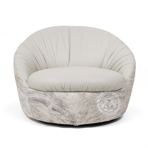 May include: A white leather swivel chair with a gray and white cowhide base.