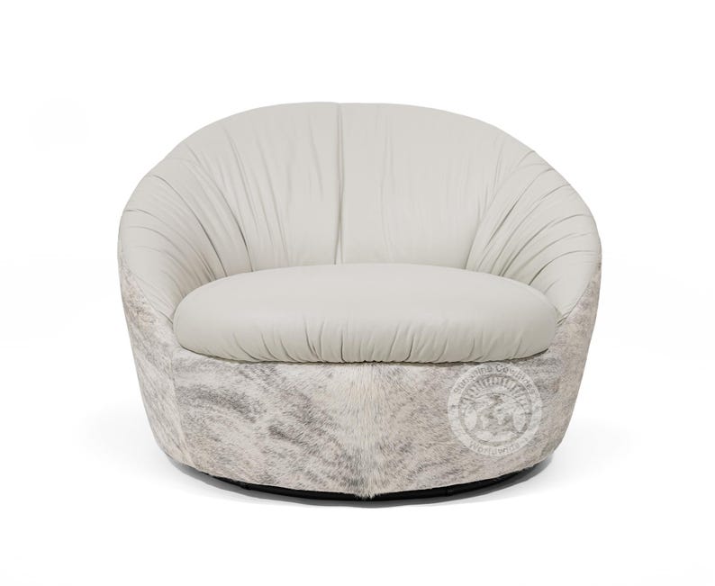 May include: A white leather swivel chair with a gray and white cowhide base.
