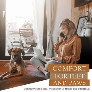 Może przedstawiać: Kobieta siedzi na brązowym dywanie ze sk&oacute;ry krowiej z psem obok niej. Rozmawia przez telefon i pracuje na laptopie. Tekst na dywanie brzmi "COMFORT FOR FEET AND PAWS OUR COWHIDE RUGS, WHERE STYLE MEETS PET-FRIENDLY!"