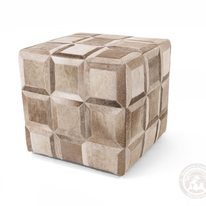 May include: A square ottoman with a patchwork design. The ottoman is covered in a mix of light and dark brown cowhide squares, creating a geometric pattern. The piece is a neutral color and would fit in many home decor styles.