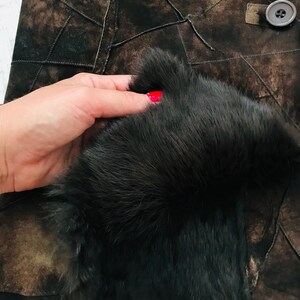 May include: A brown leather jacket with a black fur collar. The jacket is made of patchwork leather and has a button closure.