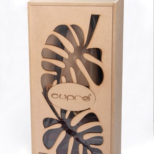 May include: A rectangular wooden box with a cut-out leaf design. The box has a clear window revealing the contents. The word "cupre" is displayed on an oval-shaped wooden label. The box is a natural wood colour.
