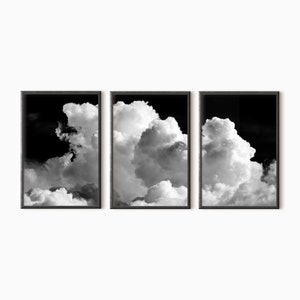 May include: A black and white triptych of three framed photographs of fluffy white clouds against a dark sky.
